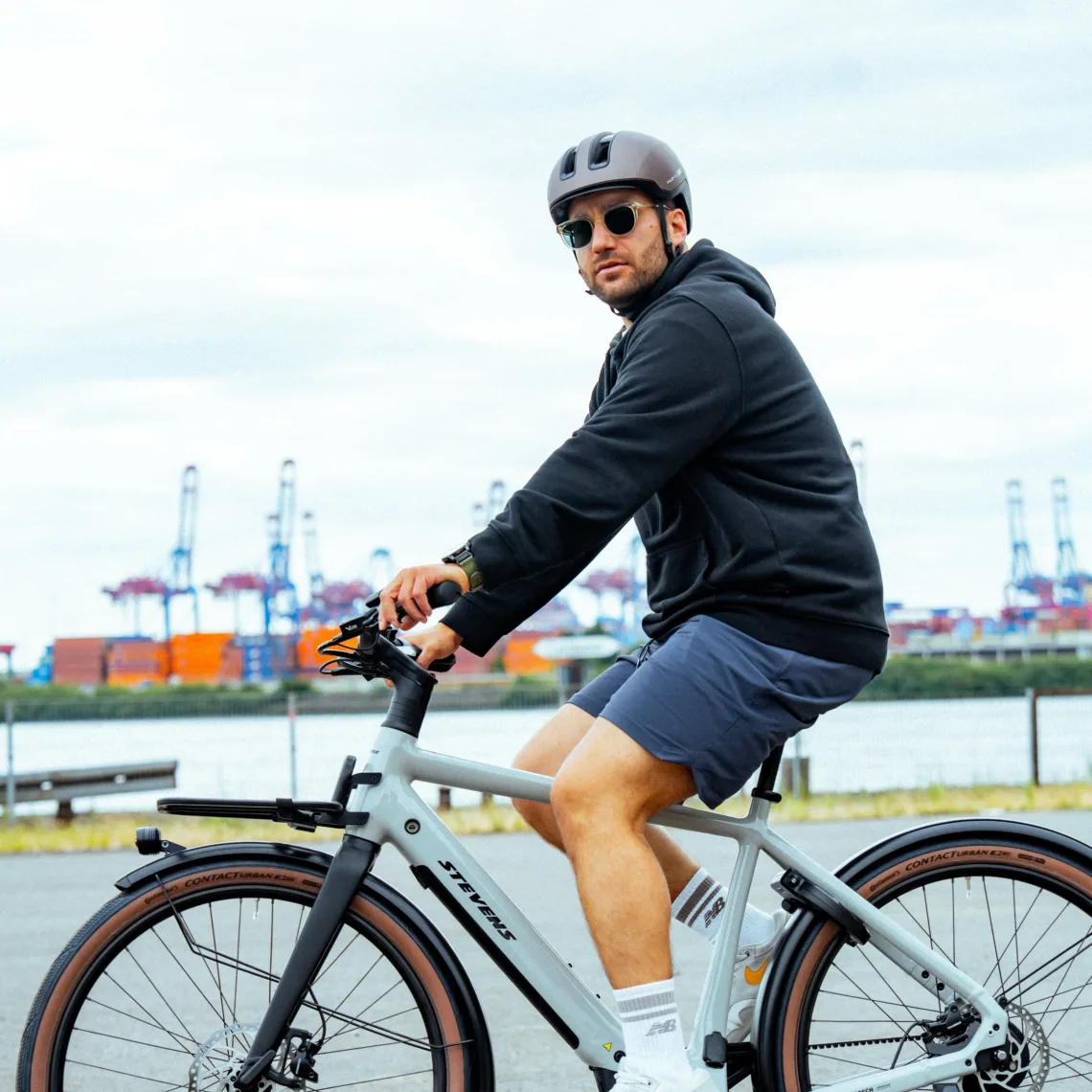 Mann auf Fahrrad seitlich und schaut zur Kamera | Rad und Tat